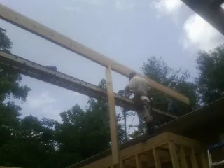 Carpenter setting a ridge beam over a new addition frame — Ice Dam Removal by Roofing Brothers in Antonito