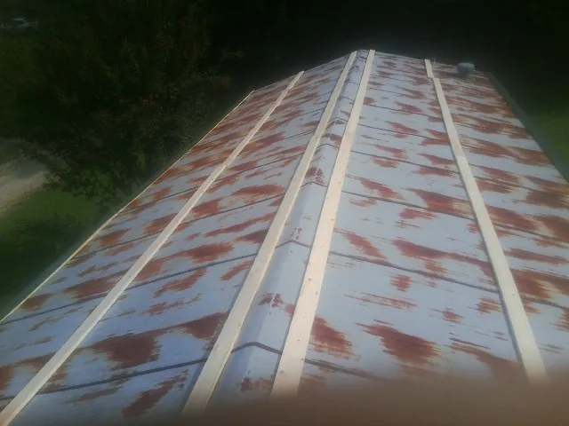 Rusted metal roof panels with new wood purlins before replacement — Storm Damage Roof Repair in Antonito by Roofing Brothers